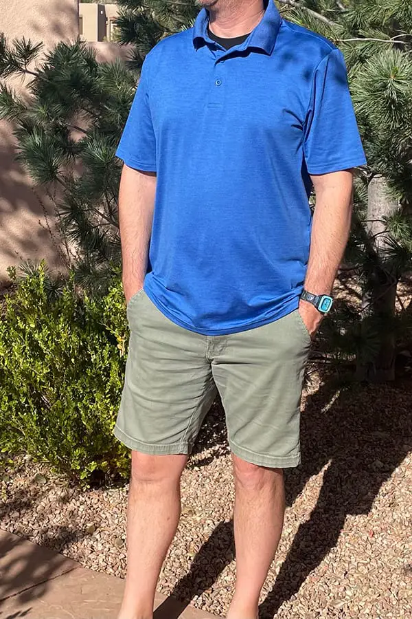 Man wearing blue polo shirt with green shorts.